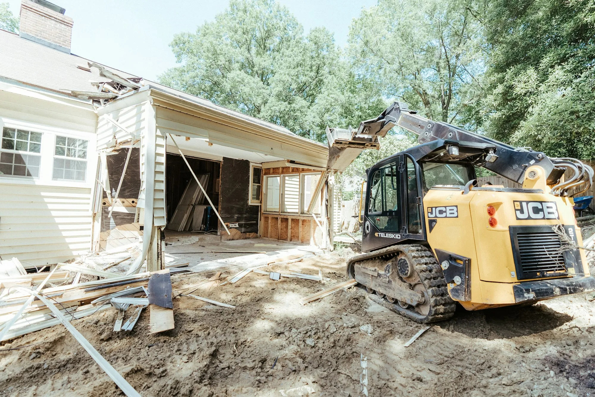 Compact loader removing debris from a house renovation