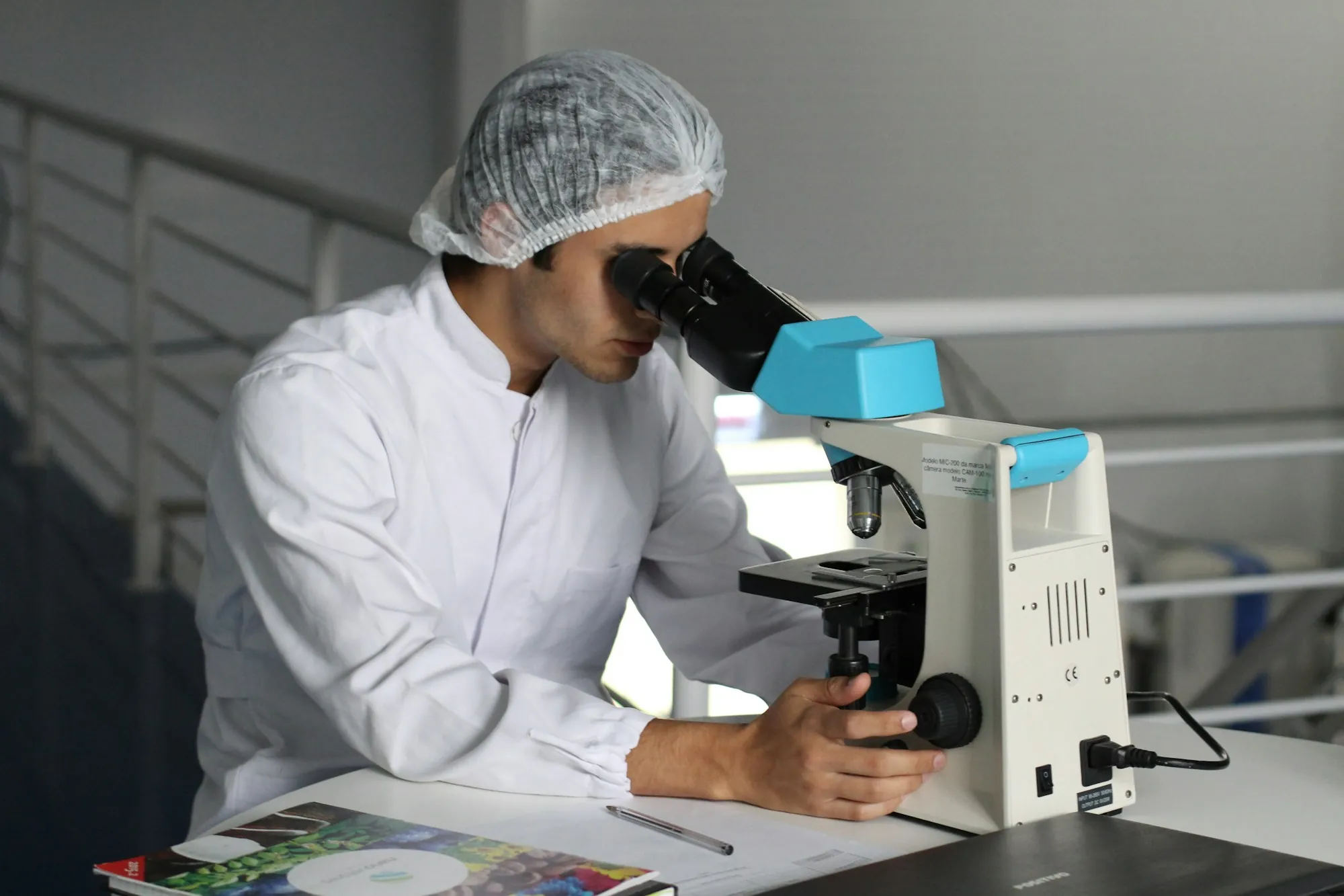 Lab analyst looking through a microscope