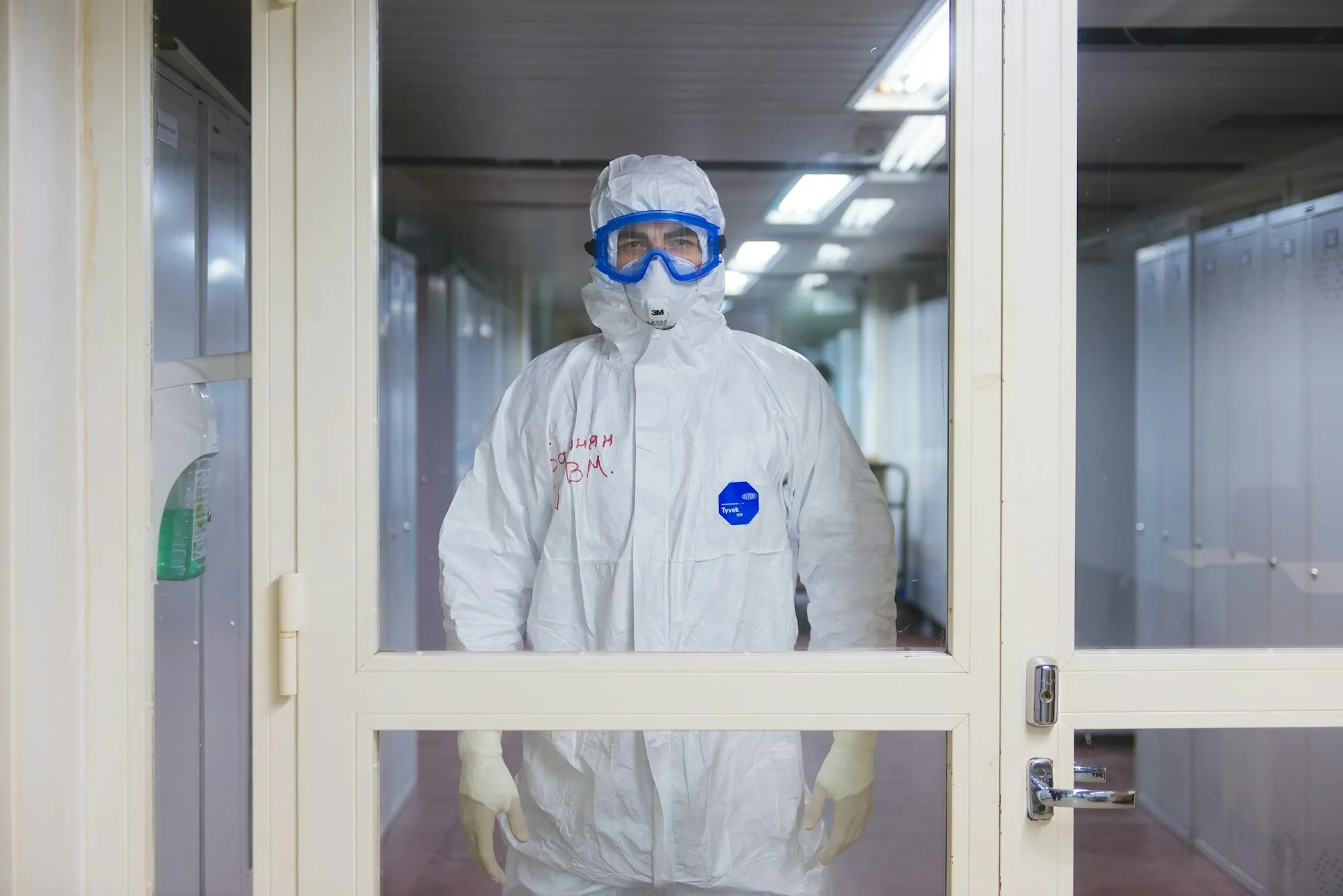 Worker in a protective suit standing in a sealed doorway